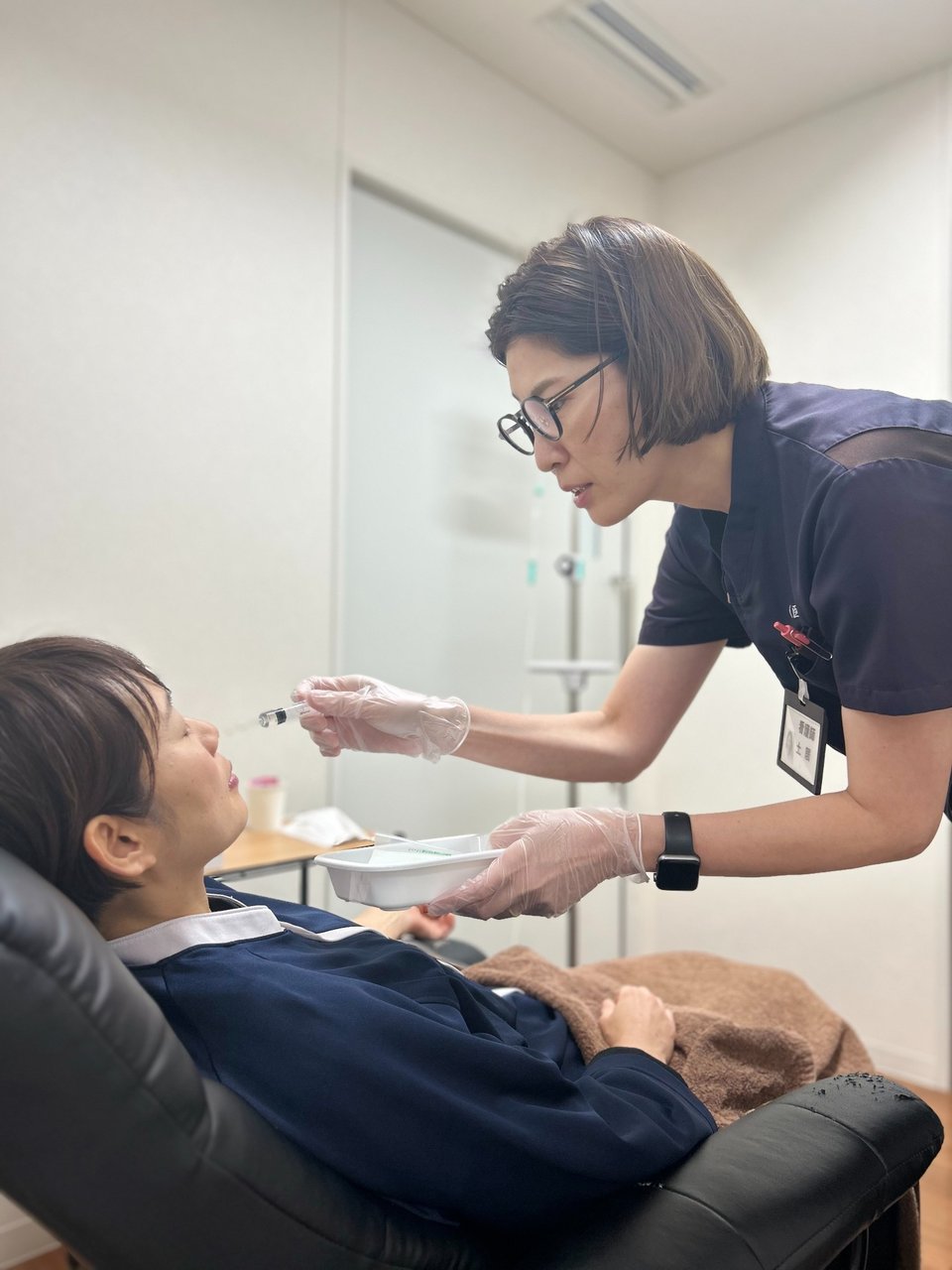 胃カメラ検査前の準備のようす。看護師が前処置を丁寧に行います。